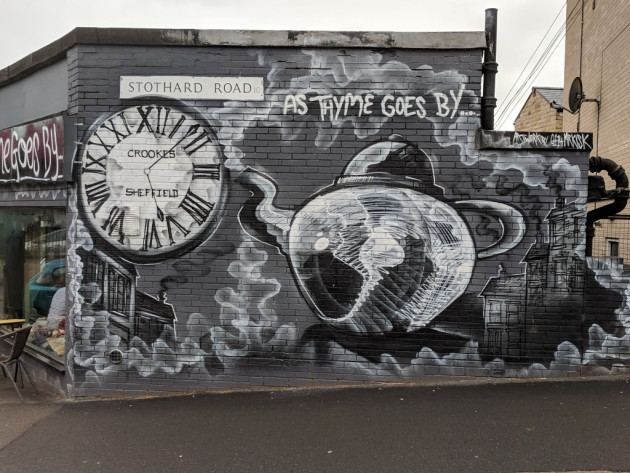 Black and white wall mural featuring a clock and a teapot